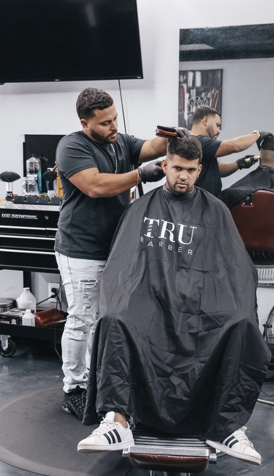 Barber working on a client at his station
